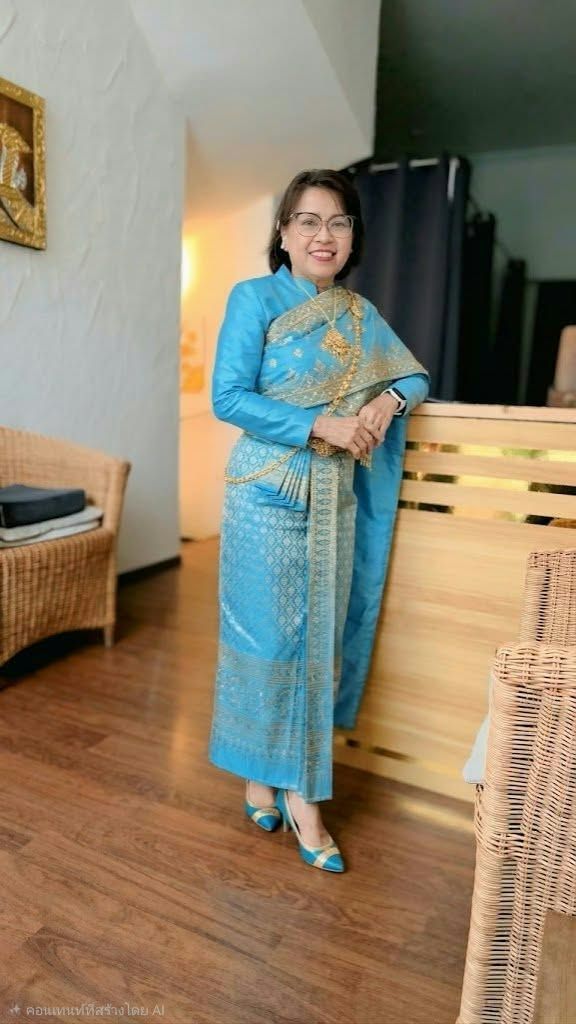 Mitarbeiterin von YADA in einem hellblauen thailändischen Kleid im Studio